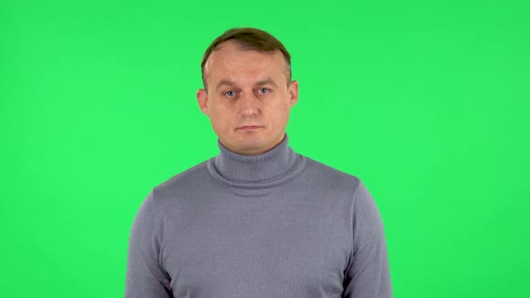 Portrait of Male Listening Attentively and Nodding His Head Pointing Finger at Viewer. Green Screen