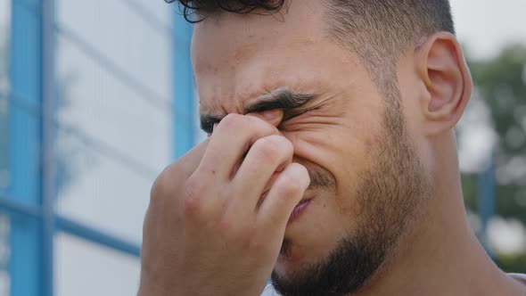 Closeup Portrait of Tired Upset Sad Young Middle Eastern Arab Man Rubbing Bridge of Nose