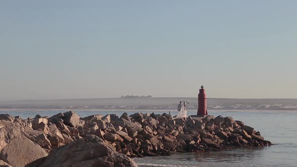 This couple walks down the pier as they are very in love and had just gotten married