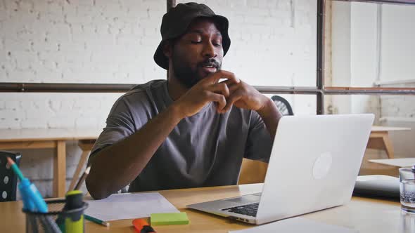 Stressed Tired Black Man Having Problems at Work Looking at Laptop Feeling Puzzled