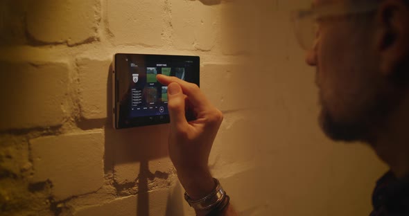 Man Checking Security Camera Through Home Hub