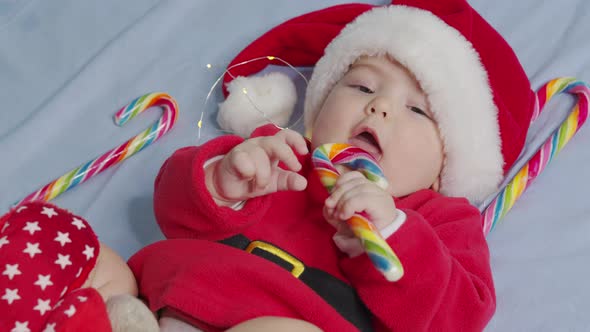 Christmas Portrait of Cute Little Newborn Baby Girl Wearing Santa Hat and Dress Winter Time