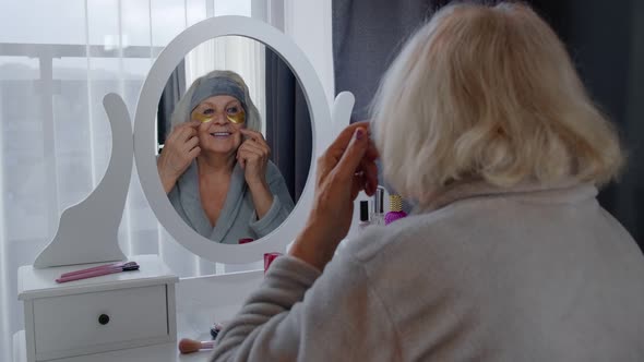 Old Senior Elderly Woman Grandmother Applying Anti-wrinkle Eye Patch, Putting Makeup on at Home