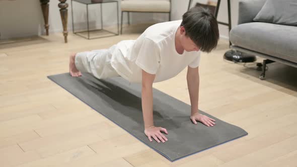 Asian Man Doing Pushups on Yoga Mat at Home