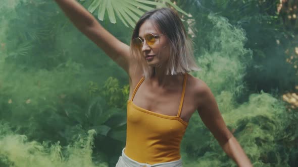 Slow Motion a Charming Young Woman Wears Casual Clothes and Yellow Sunglasses Having Fun Holding in