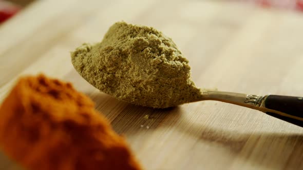 Turmeric powder, ed chili powder and coriander powder on a wooden table 4k