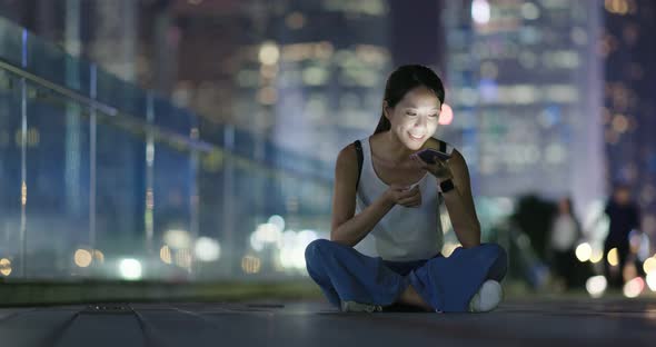 Woman use of smart phone in city at night