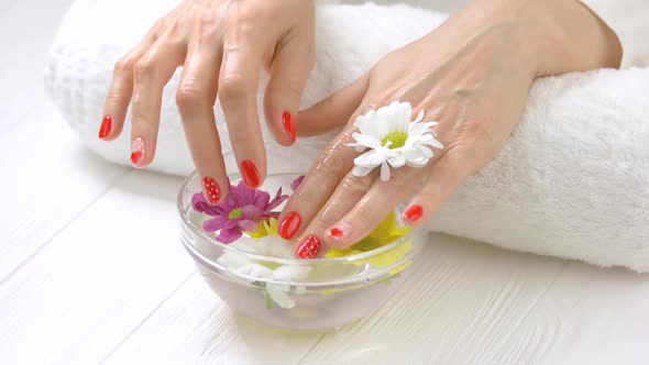 Wet Manicured Hands in Glass Bowl.