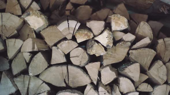 Man Puts Chopped Wood Pieces Neatly Onto One Each Other in a Pile. Stacked Wood Is Ready and Dried