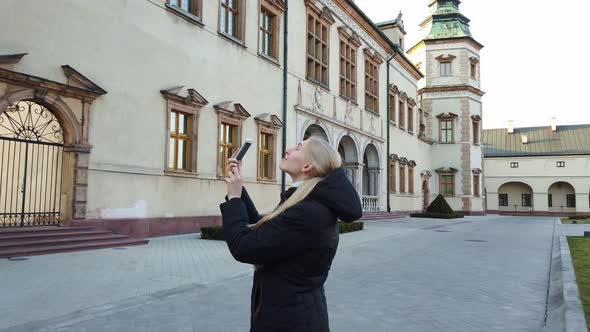 Girl Tourist Makes a Photos of Palace in the Old City.