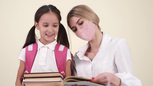 Mother and Daughter Preparing Backpack for School