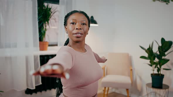 Portrait of Calm Sporty African American Woman Standing in Warrior Position Practicing Yoga at Home