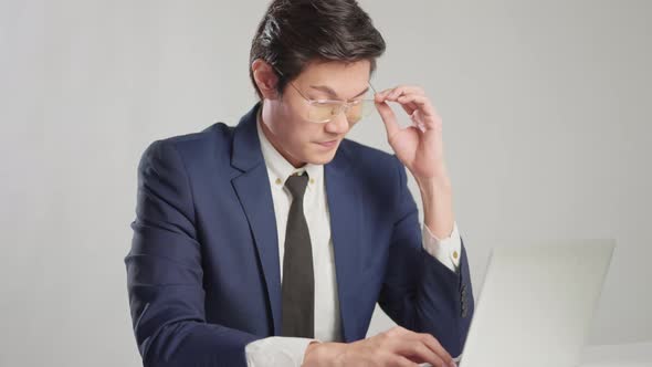 asian businessman wear formal suit sitting in office feeling body pain by office syndrome