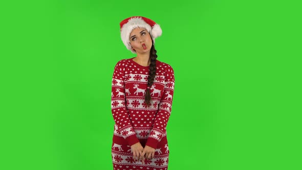 Sweety Girl in Santa Claus Hat Is Making Funny Faces. Green Screen