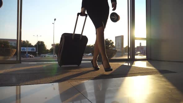 Business Lady Going To the Airport with Her Luggage. Young Woman in Heels Entering Walking Through