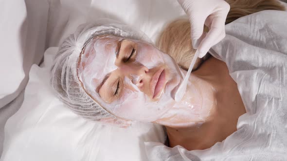 Doctor Applies an Anesthetic Cream on the Face of His Patient Lying