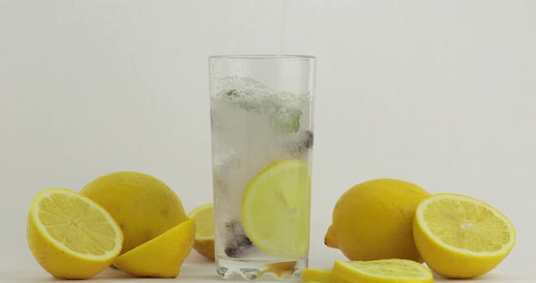 Pour a Cold Soda Drink. Lemon and Ice in a Drink Glass. Refreshing Cocktail