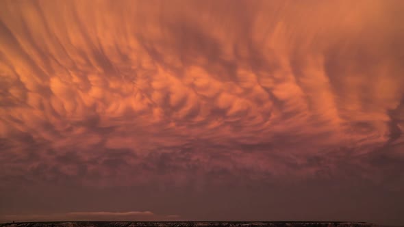 Colorful time lapse of mammatus clouds changing color during sunset