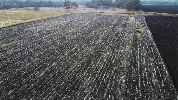 Aerial Drone View Flight Over Field of Plowed Brown Earth