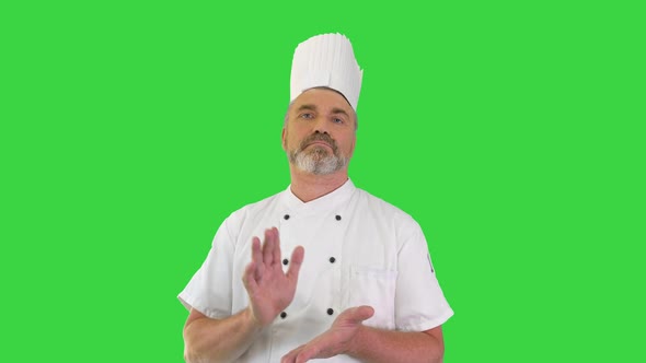 Mature Chef Looking at Camera While Clapping His Hands Acclaiming on a Green Screen Chroma Key