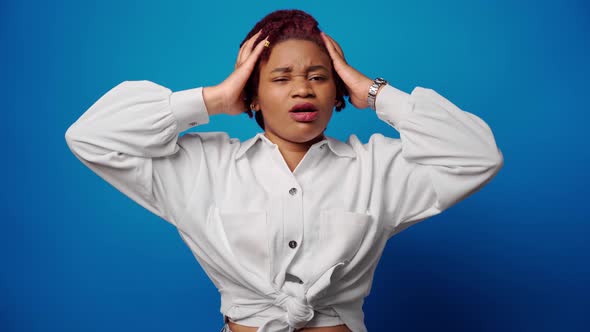 Stressed Exhausted Afro Woman Suffering From Headache Against Blue Background