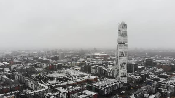 Drone flying sideway to the right while it is snowing, Turning torso, Malmö, Sweden