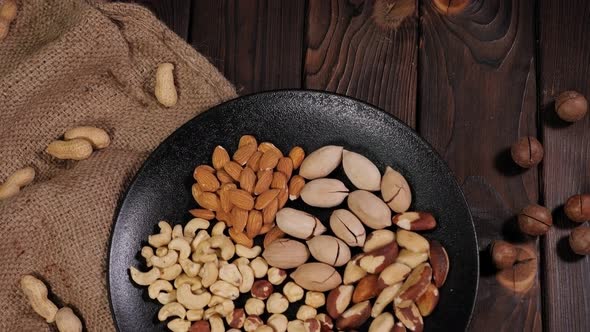 Closeup of Various Nuts in a Plate on a Wooden Background