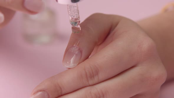 Woman Hand on Pink Makes Manicure for Herself