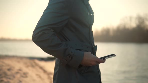 Holding Smartphone In Hands Outdoors. Using Mobile Phone On Nature. Businessman Chatting On Mobile.