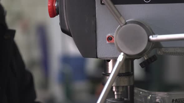 Hand Moving Down Pilot Feed Lever Of A Drill Press Machine (Boor Machine) - close up