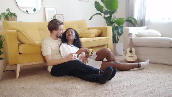 Young Multiethnic Couple Affectionately in the Living Room of an Apartment