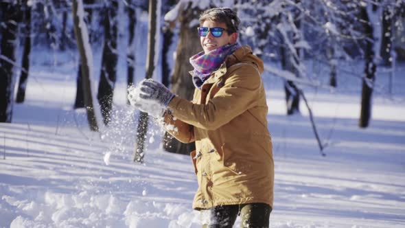 Happy Young Man Throwing Snow Up in Front of Camera in Slow Motion