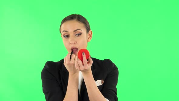 Girl Paints Her Lips Looking in Red Mirror