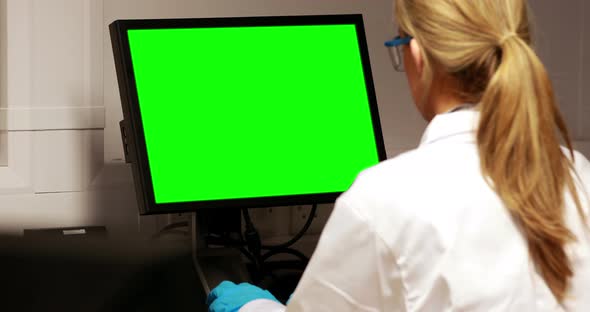 Scientist using computer with chroma key screen