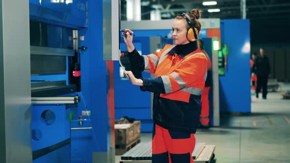 Female Worker Using Touchscreen with a Stylus at a Modern Factory