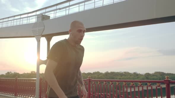 Exhausted Sports Man Taking Breath After Running on the Pedestrian Bridge