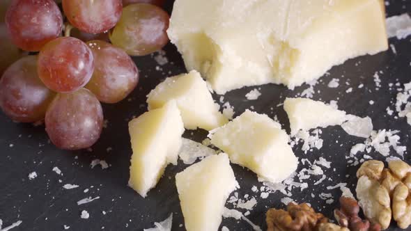 Sliced Cheese Nuts Grape Honey and Knife on Shale Platter