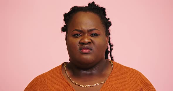 Black Plump Woman Poses Expressing Disagreement for Camera
