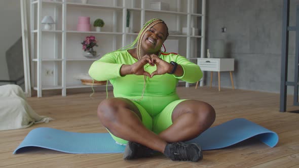 Cheerful Overweight Woman Showing Heart Shape