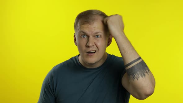 Portrait of Young Caucasian Man Posing in T-shirt. Dissatisfied Guy Puts Hand on Face, Facepalm