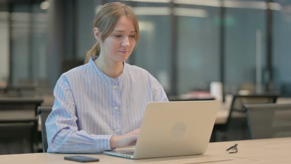 Young Woman Working on Laptop in Office