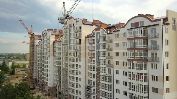 Aerial view of tall residential building under construction in a city.