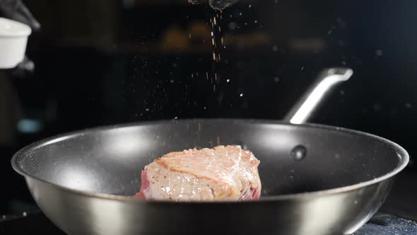 Food Video and Cooking Process Shot in Slow Motion. Chef Seasoning Meat on Frying Pan with Paprika