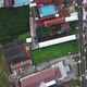 drone view of residential settlements around green rice fields - VideoHive Item for Sale