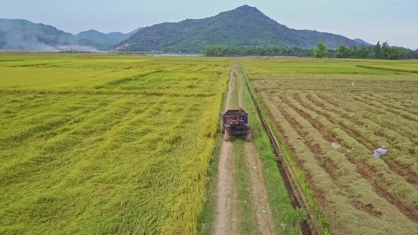 Drone Flies Over Lorry Driving Along Ground Road By Fields