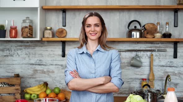 Modern Housewife Posing at Kitchen Surrounded By Food and Dishes