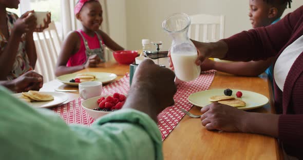 Three generation african american family having breakfast together at home