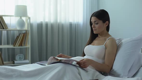 Beautiful Woman Reading Glossy Magazine With Interest, Pleasant Pastime at Home