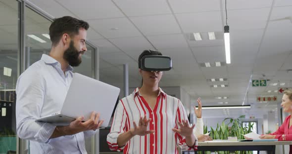 Happy diverse male and female business colleagues using vr headset in office