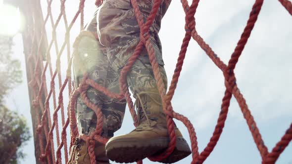 Military soldier climbing a net during obstacle course 4k